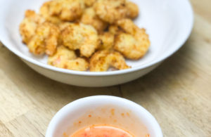 bowl of bang bang shrimp sauce in front of bowl of air fried shrimp